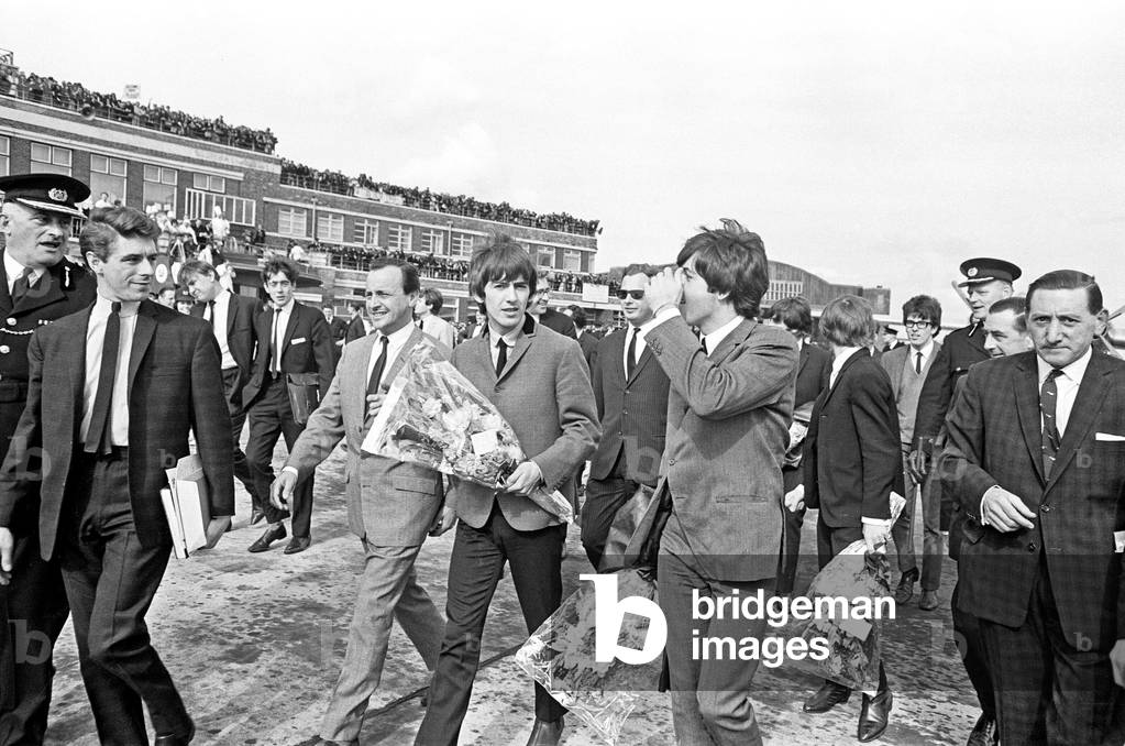 The Beatles in Liverpool for the Premier of a Hard Day's Night. Paul McCartney and George Harrison walk down the concourse of the Liverpool airport they flew into for the premier. 10th July 1964.