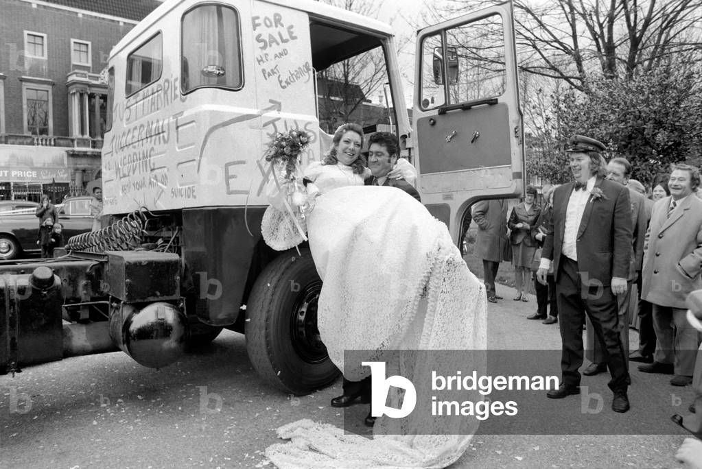 Jock Edwards with his bride, Jill Crawford, after their marriage at St. John's Church, Leytonstone, E, 11. They are pictured with the 32 ton Juggernaut Truck they travelled in from the Church to the reception, April 1975 (b/w photo)
