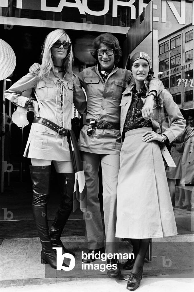 Yves Saint Laurent, designer pictured outside his first London Rive Gauche store on New Bond Street, London, opening day of boutique, and with muses Louise de La Falaise, aka Loulou (right) and Betty Catroux (left). 10th September 1969 (b/w photo)