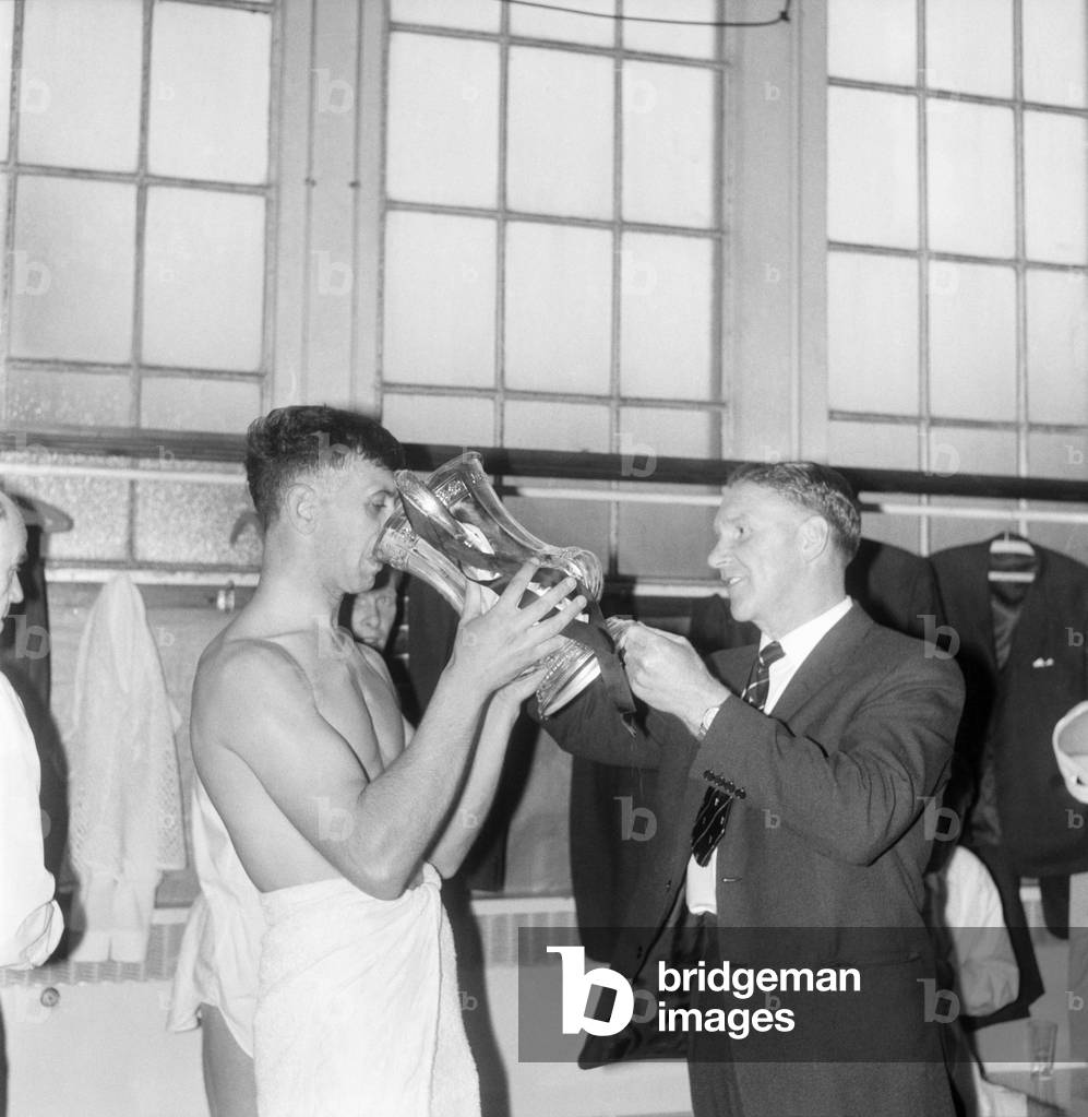 FA Cup final at Wembley stadiumTottenham Hotspur 3 v Burnley 1. Spurs team celebrate by drinking champagne from the trophy in the dressing room after the match. manager Bill Nicholson holding the trophy. May 1962 (photo)