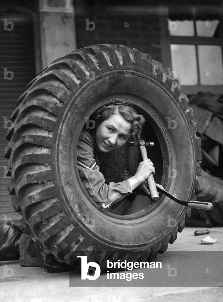 Keeping the Army Supplied. Scenes at an Ordance depot in the Home Counties. Lance Corporal Kittly Cummins of the ATS, a tyre examiner at work. May 1944