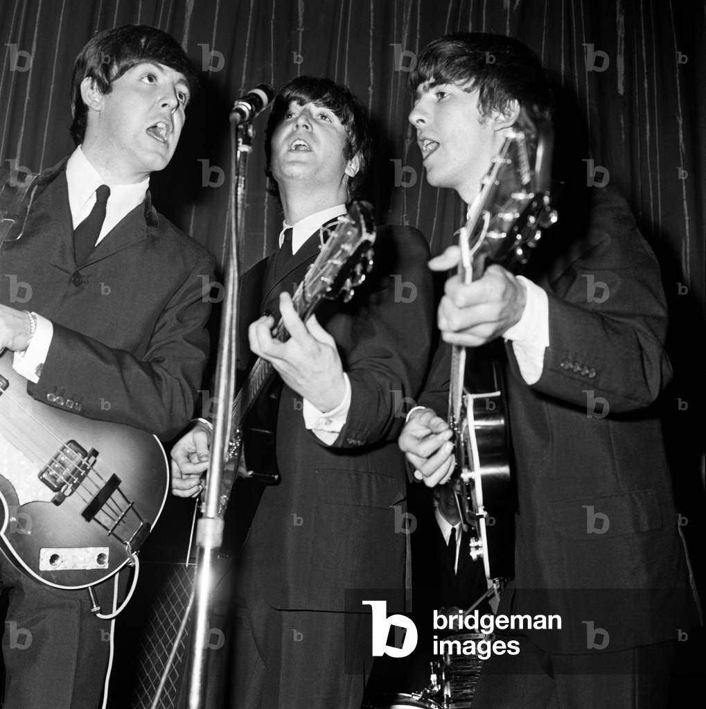 Paul McCartney, John Lennon and George Harrison of the Beatles seen here performing on stage, November 1964 (b/w photo)