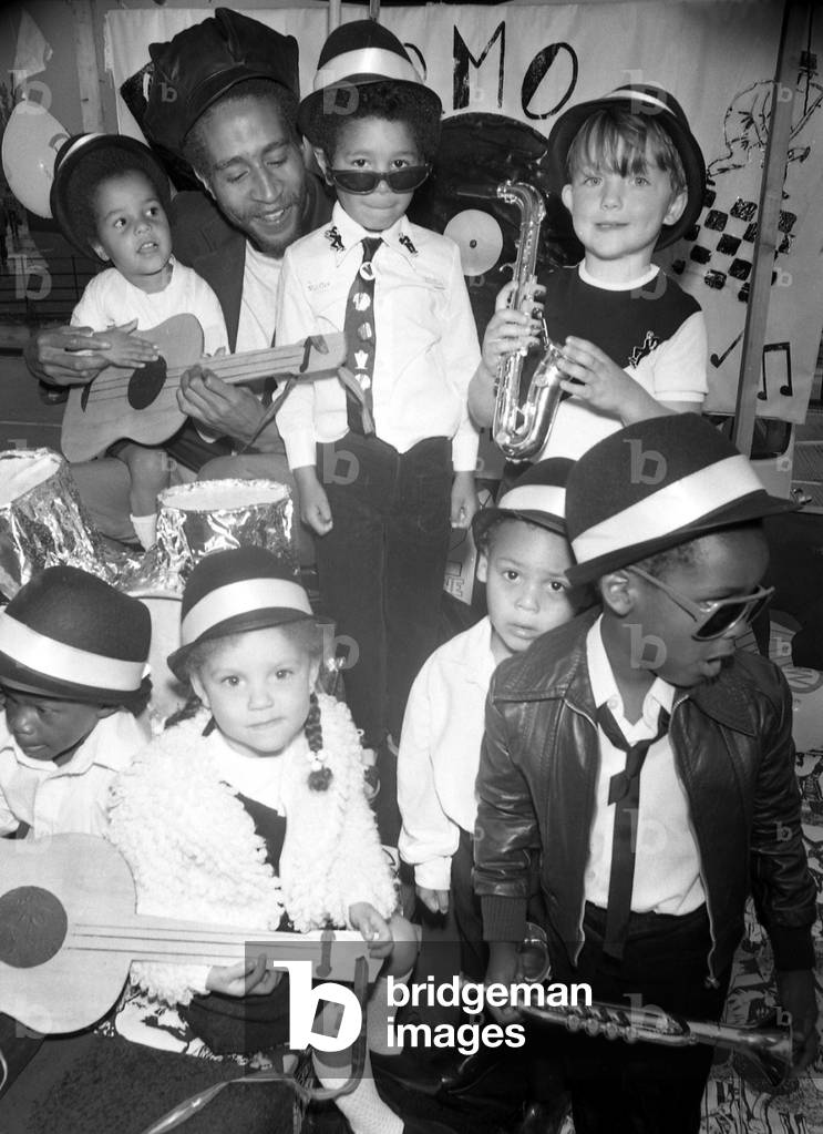 Charlie Anderson, guitarist with The Selector, joined children on a Two-Tone float during Coventry carnival, 14th June 1980 (b/w photo)