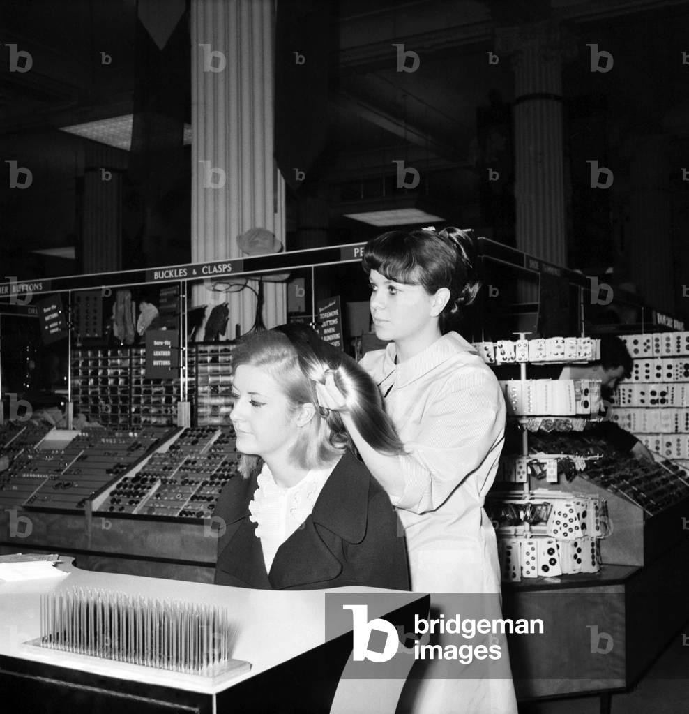 Woman at the beauty department of Selfridges store having a Tovar- tress attached to her hair, 1966 (b/w photo)