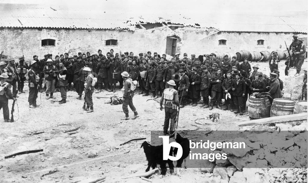 Libya. British infantry in possession of an Italian fort after the capture of Derna, with their captives lined up in the square, March 1st 1941 (b/w photo)