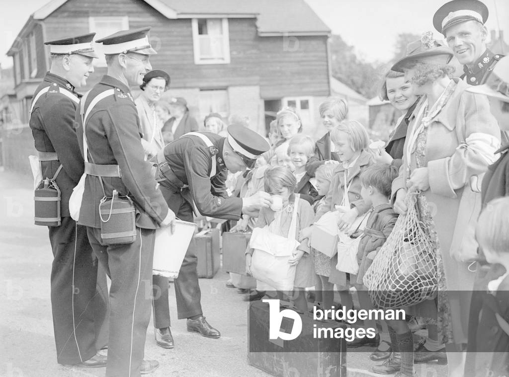 Members of the St John Ambulance Service giving the children awaiting evacuation a drink of water. while they wait for their transport out of the city, 3rd September 1939 (b/w photo)