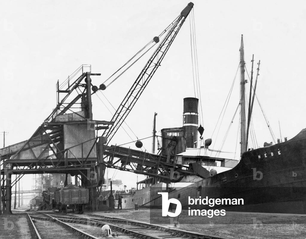 A ship loading anthracite coal by conveyor at the Swansea docks.
Circa January 1937