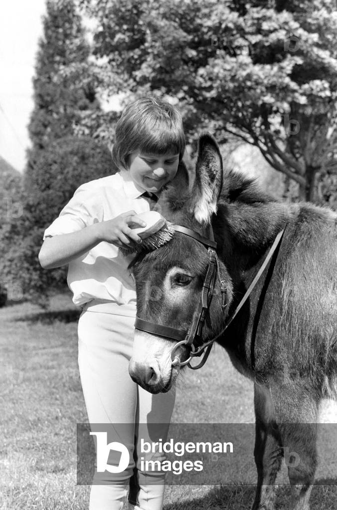 Nine year old girl with donkey at the Donkey racing championships, May 1975 (b/w photo)