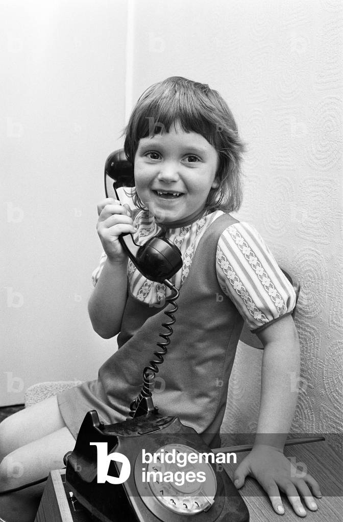 Six year old Jayne Myers receives her weekly phone call from Five year old boyfriend Andrew Butler who calls her from the phone box at the end of his road. 6th September 1972 (b/w photo)
