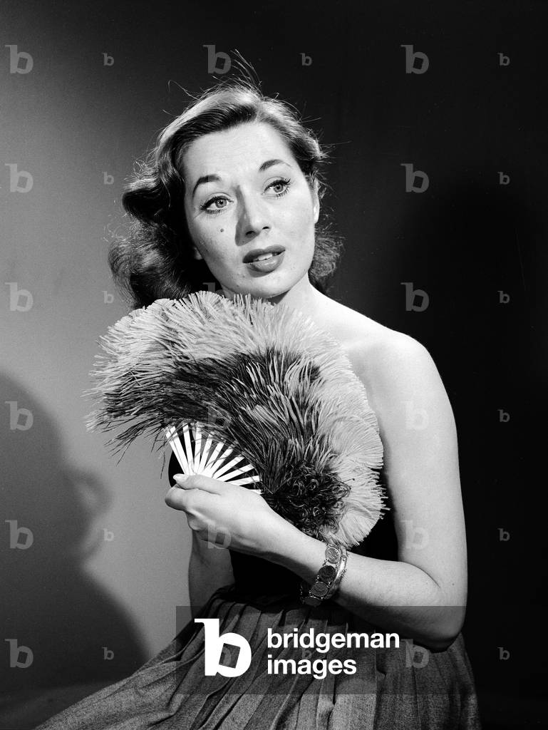 Model with fan in strapless dress. Model with fan in strapless dress., c. 1964 (b/w photo)