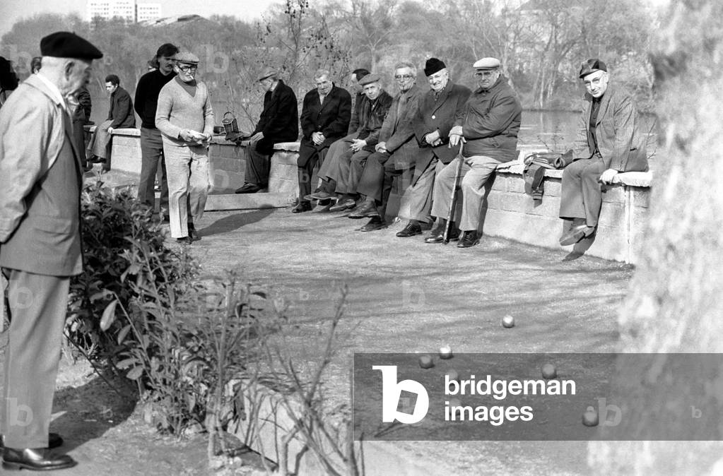 Off duty Renault car factory workers playing Boules watched by retired workers in Paris, April 1975 (b/w photo)