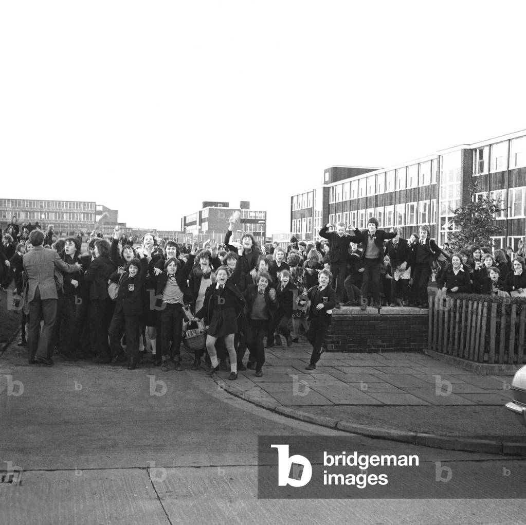Pupils storm out of Kenton School, Newcastle, and run round the grounds chanting in protest at having to wear school uniforms, on November 11, 1974 (b/w photo)