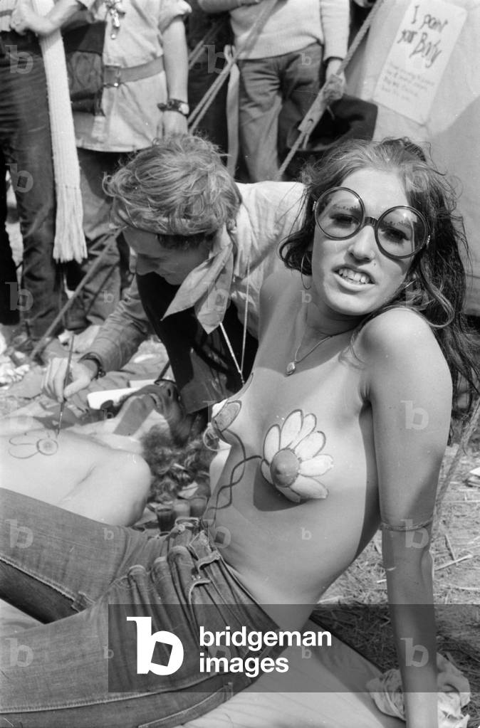 Hippy girl having her breasts painted at the Isle of Wight Pop festival.
27th August 1970