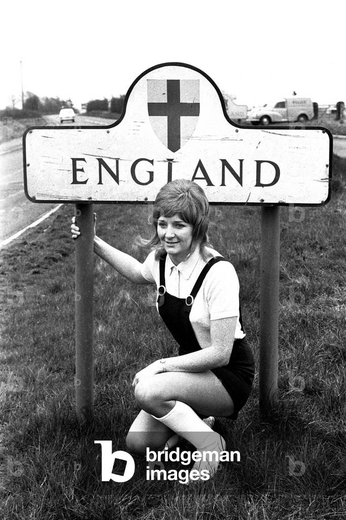Disc jockey Jimmy Savile during his 1000 mile charity walk from John o'Groats to Land's End. One of Jimmy Savile's entourage at the England border road sign. 12/03/1971 (b/w photo)