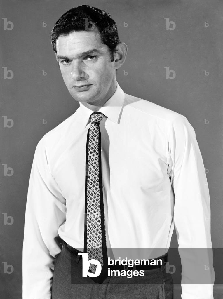 Clothing: Fashion: Menswear: Man wearing shirt and tie. Model: Mike Lester. 1964 (b/w photo)
