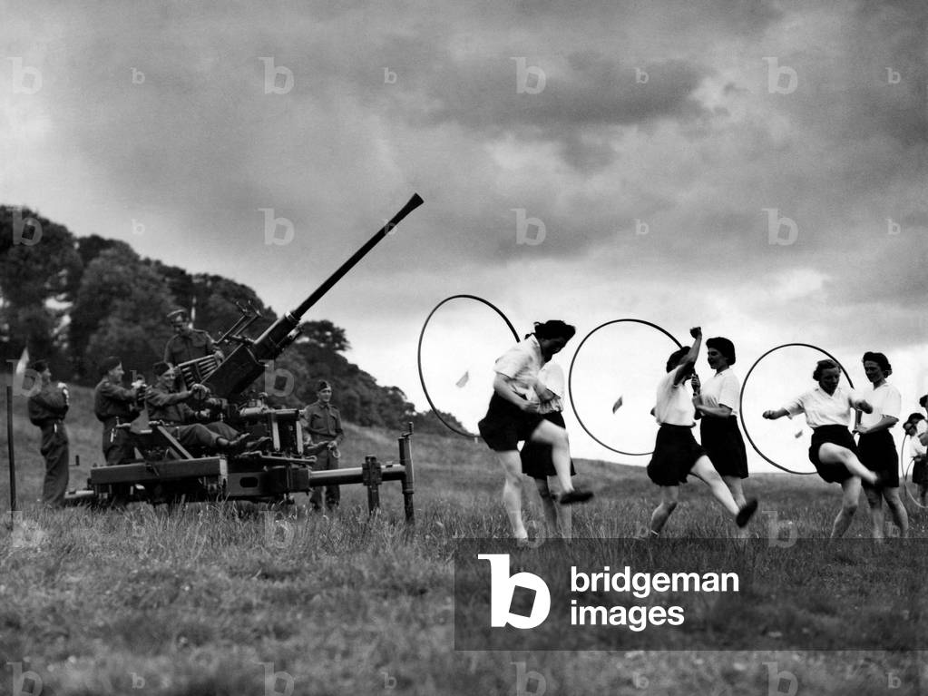 Member of the ATS seen taking exercise at a Anti Aircraft gun emplacement. 
July 1942