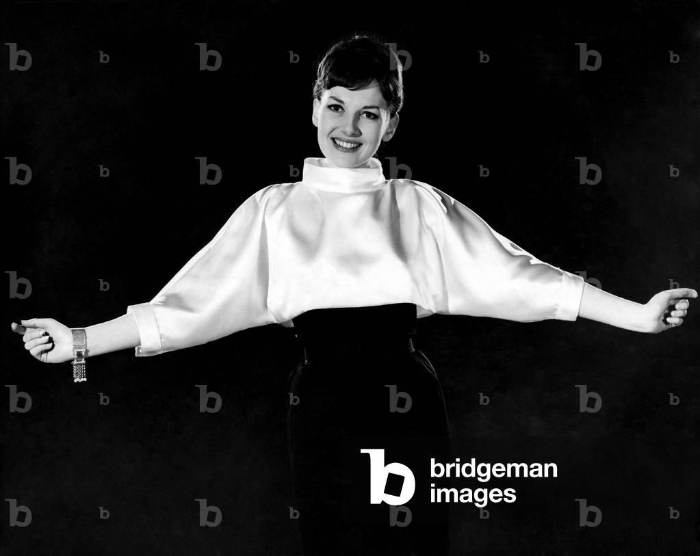 Woman wearing silk white shirt with black skirt. Reveille Fashions. Diana Lovell. February 1960