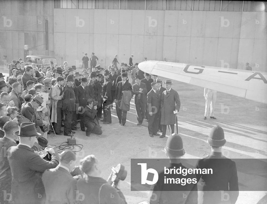 British Prime Minister Neville Chamberlain speaks with a German Embassy official as he departs Heston airfield for a meeting with German Chancellor Adolf Hitler in his Berchtesgaden mountain retreat, 15th September 1938 (b/w photo)
