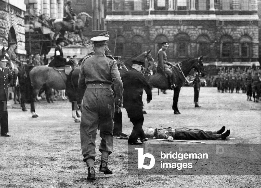 A Soldier passes out during the trooping of the colour ceremony. 
June 1947