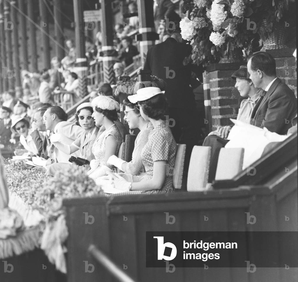 Queen Elizabeth II seen here chatting with Princess Margaret in the royal box at the Olympic Stadium in Stockholm on the opening day of the Equestrian Olympic Games. For the first time, the competitions took place in two countries. As the equine quarantine law was too strict to allow the entry of foreign horses into Australia. 10th June 1956 (b/w photo)