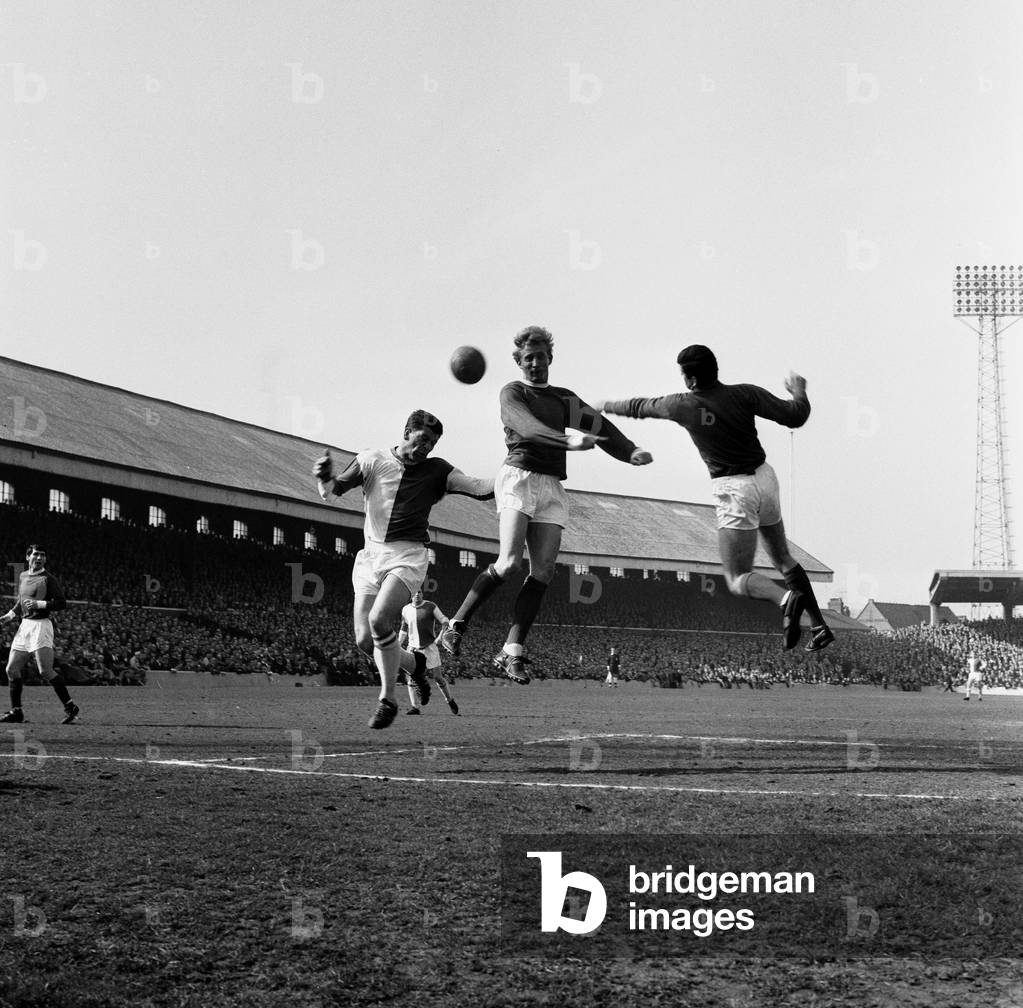 Blackburn Rovers v Manchester United, league match at Ewood Park, Saturday 3rd April 1965. Denis Law in defence, aids keeper Pat Dunne, by clearing ball from Andy McEvoy. Final Score:Blackburn Rovers 0-5 Manchester United (photo)