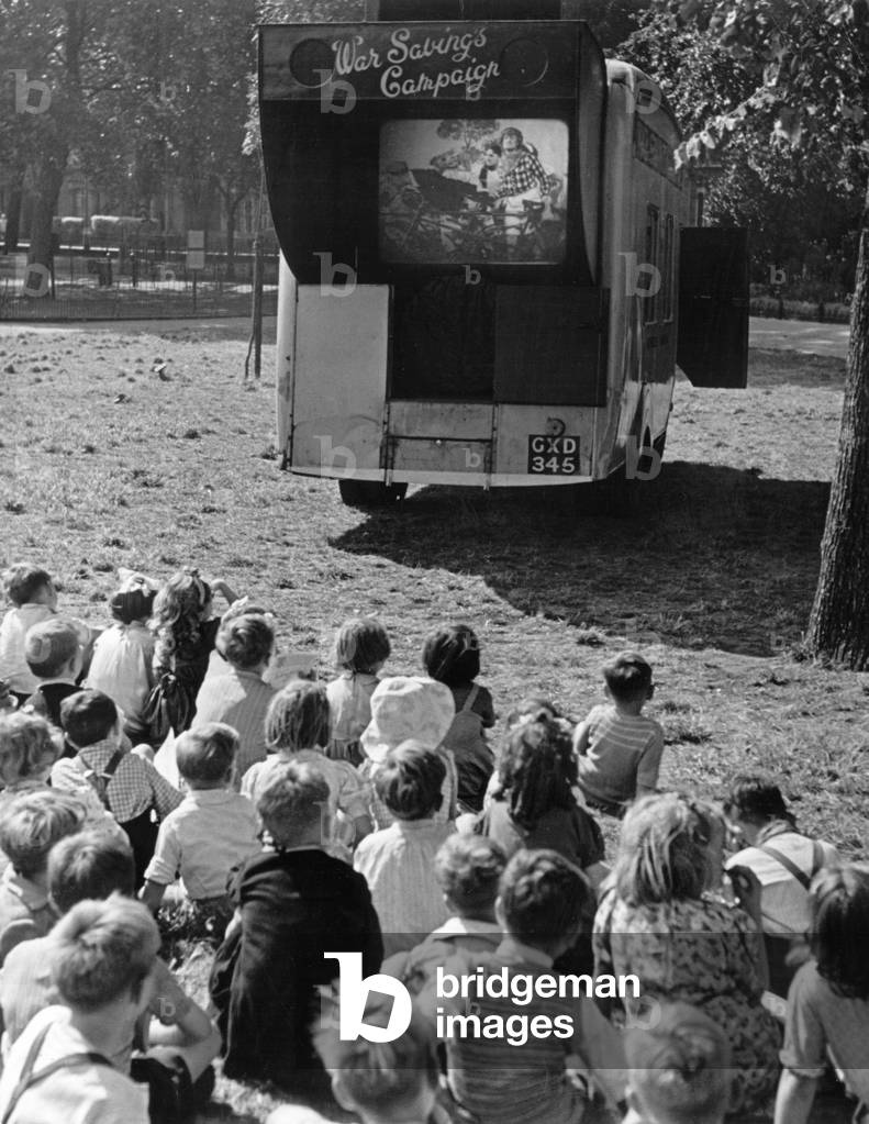 Children watch an open air cinema performance of Ralph Reader's 