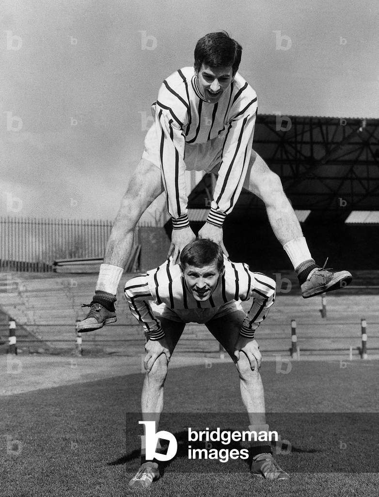 Dunfermline football player Bert Paton leap frogs teammate Alex Ferguson during a training session. March 1966 (photo)