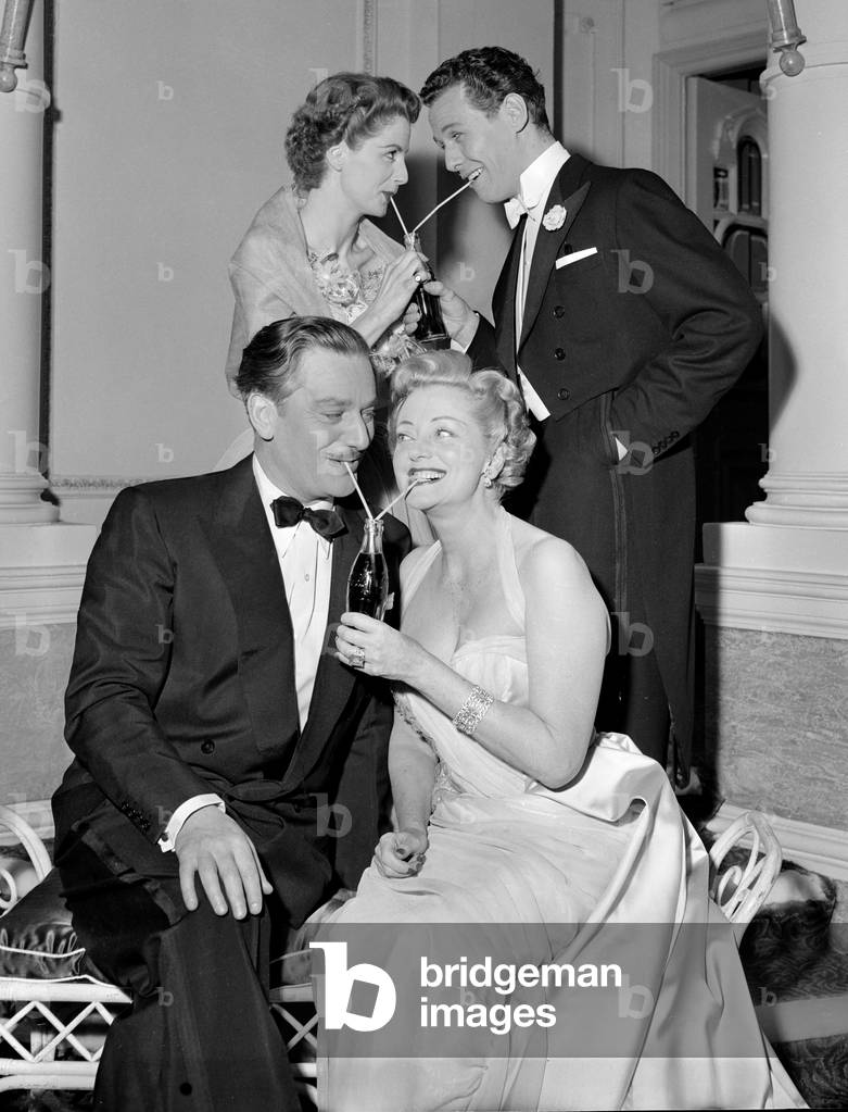 Two couples sharing bottles of coca cola at a party., c. 1954 (b/w photo)