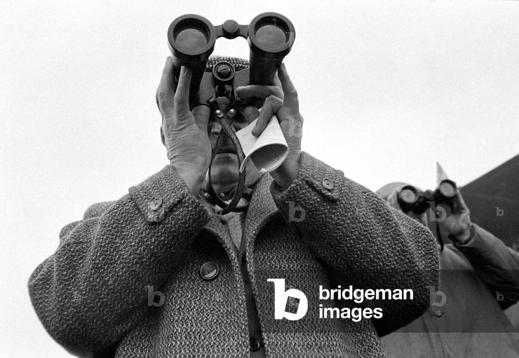 A punter watching the race through binoculars after making his bet
march 1963