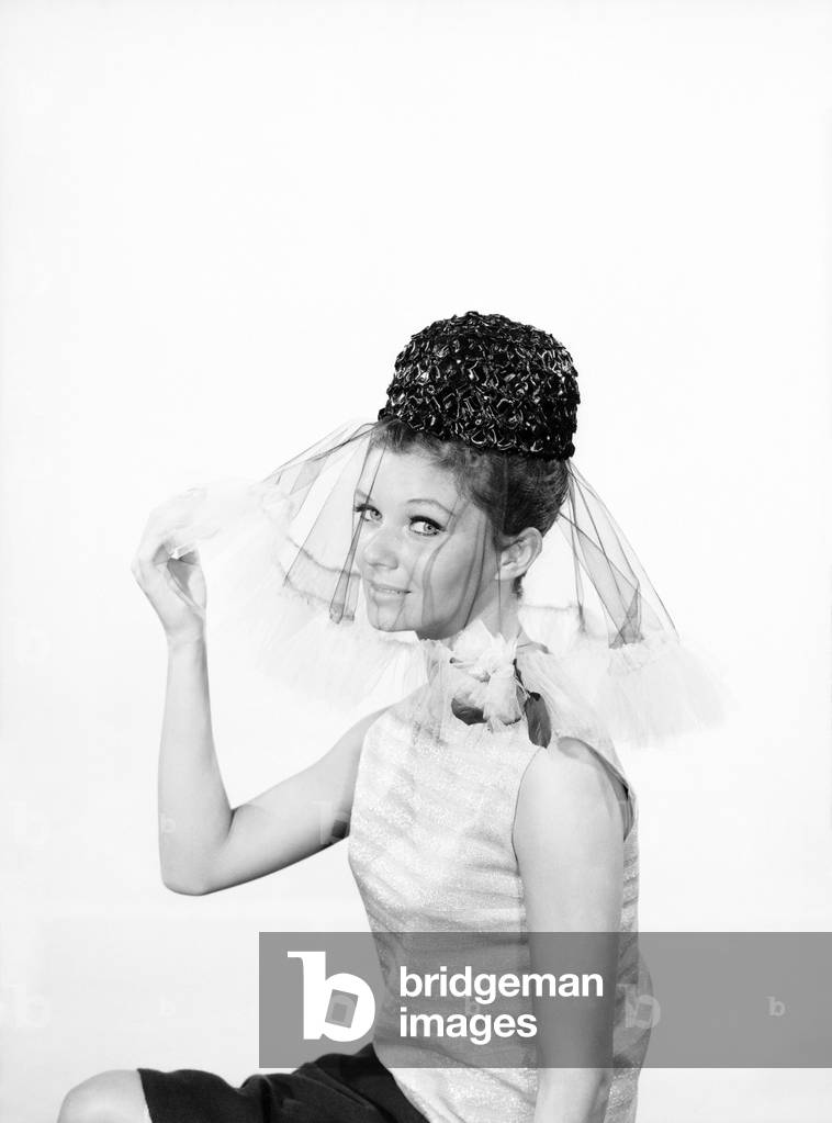 Woman wearing hats with veils, 1962 (b/w photo)