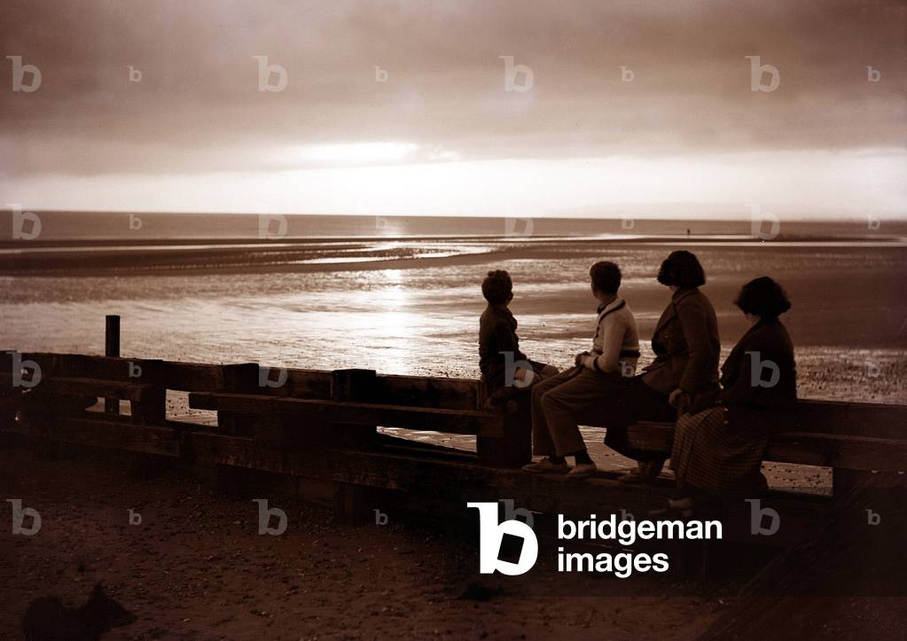Darkness falls around them as they watch the sunset at Rye Bay Sussex, June 1935 (b/w photo)