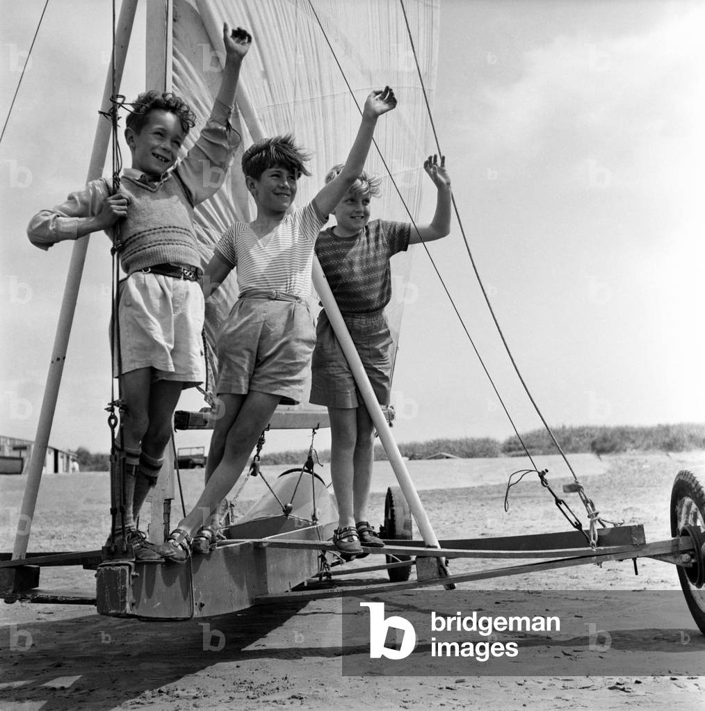 Blackpool beach lost children/sailing/crowds: Three boys on a yacht