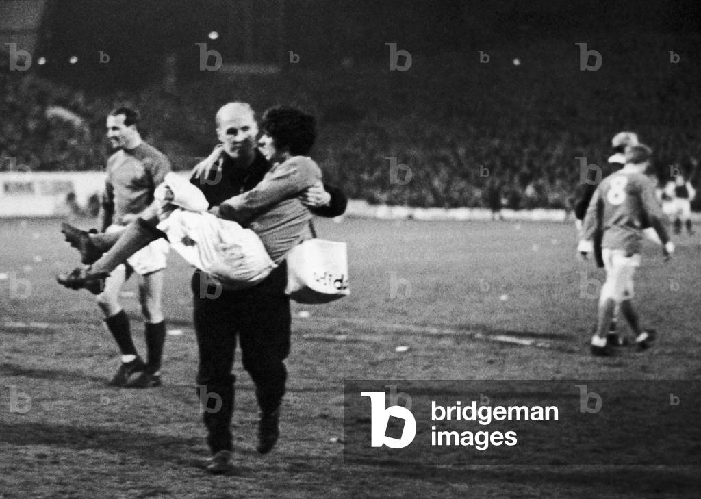 Manchester United footballer George Best is helped off the pitch by trainer Jack Crompton after becoming injured during the league match against Sheffield Wednesday at Hillsborough. 10th April 1967 (photo)