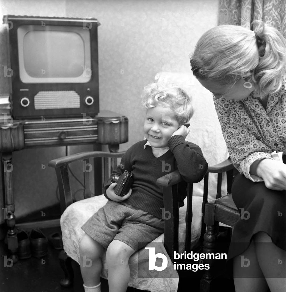 Children's Expressions: A bashful Kenneth Knowles of Manchester seen here at home with his mother. September 1957 (b/w photo)