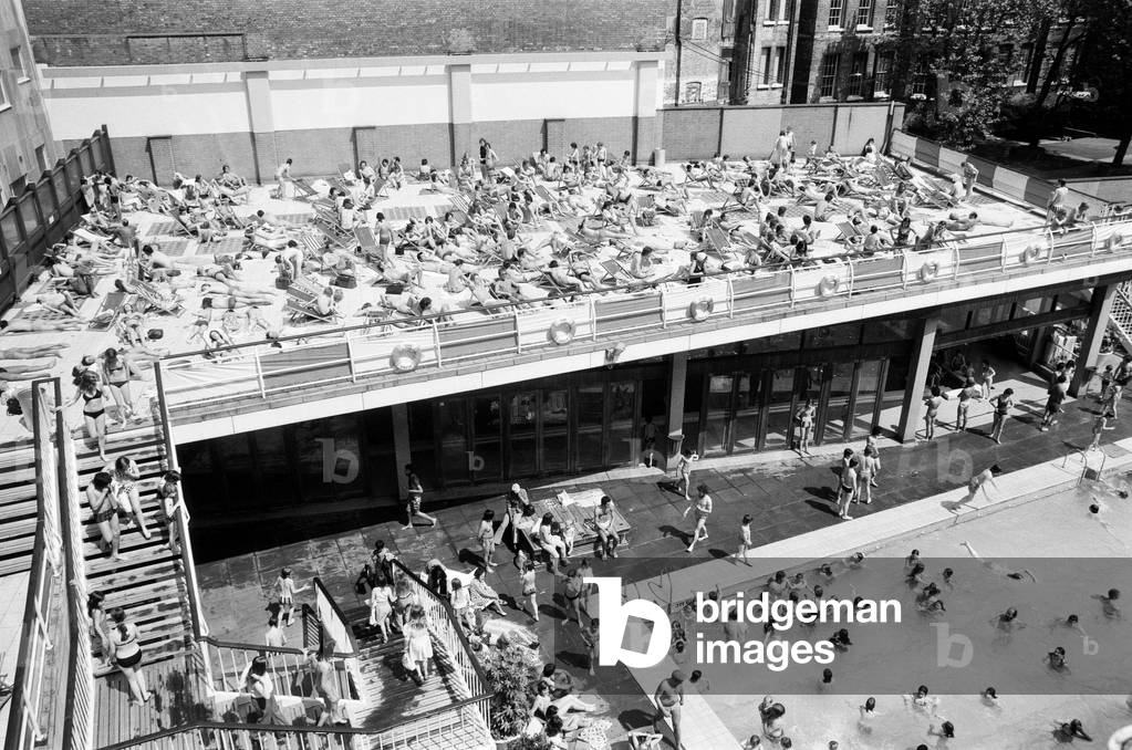 People enjoying the hot weather at the Oasis outdoor swimming pool Lido, London. 7th June 1975 (b/w photo)