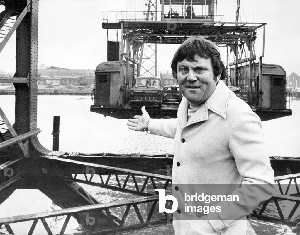 Terry Scott, actor poses for pictures next to the Tees Transporter Bridge, Middlesbrough, 5th March 1974 (b/w photo)
