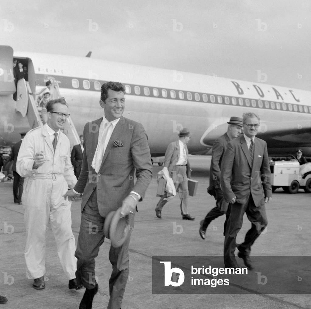 Frank Sinatra seen here arriving at Heathrow airport in the summer of 1961 with Dean Martin men singers entertainment holding hat walking across airport apron Three piece suit August 1961 (b/w photo)