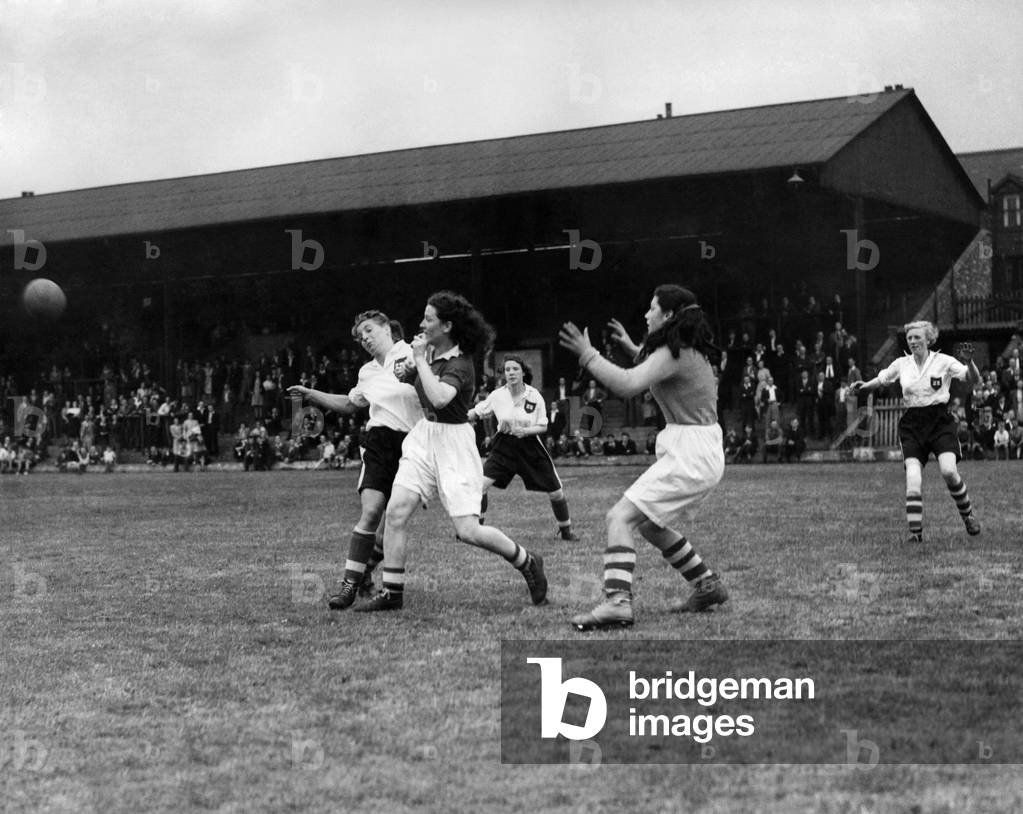 Ladies Association Football. England v. Scotland. A Scottish defender makes a vigorous clearence from an England forward while 15 years old Jennie Baillie the Scottish goalie awaits events with open arms. July 1948 (photo)