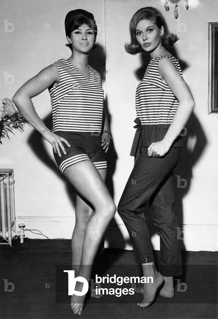 Clothing Beach. Seen at the Slimma show in London today, (left) navy and white striped poplin slipover top with navy striped-trimmed shorts to match. (Right) striped poplin overblouse with navy pants. Slipover 110s 9d. Shorts 25/- Overblouse 116s. Pants 114s 3d. November 1961 P017988