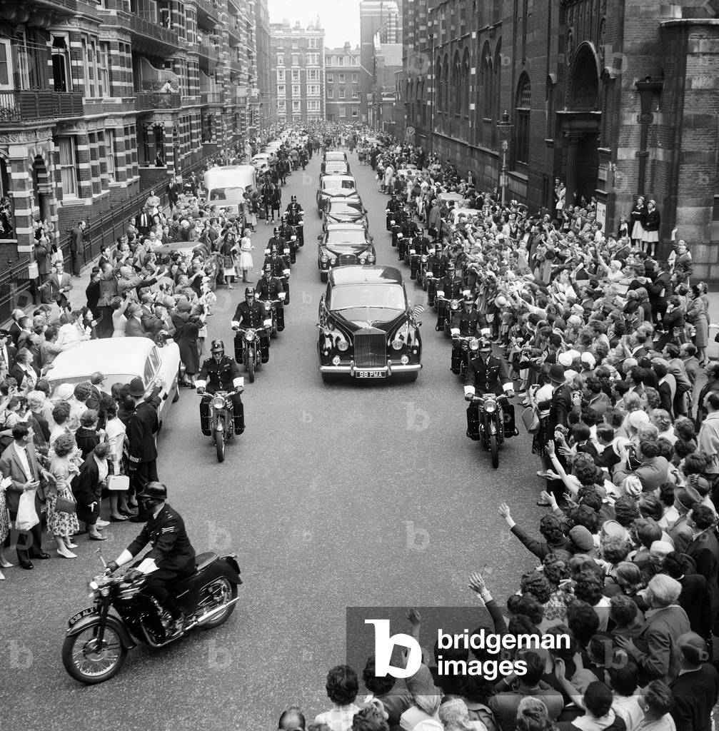 Second day of the private visit to London of American President John F. Kennedy and the First Lady Jacqueline Kennedy for the christening ceremony of their niece Anna Christina Radziwill, held at Westminster Abbey. An escort of motorcyclists flank the President's car as he leave the christening. 5th June 1961 (b/w photo)