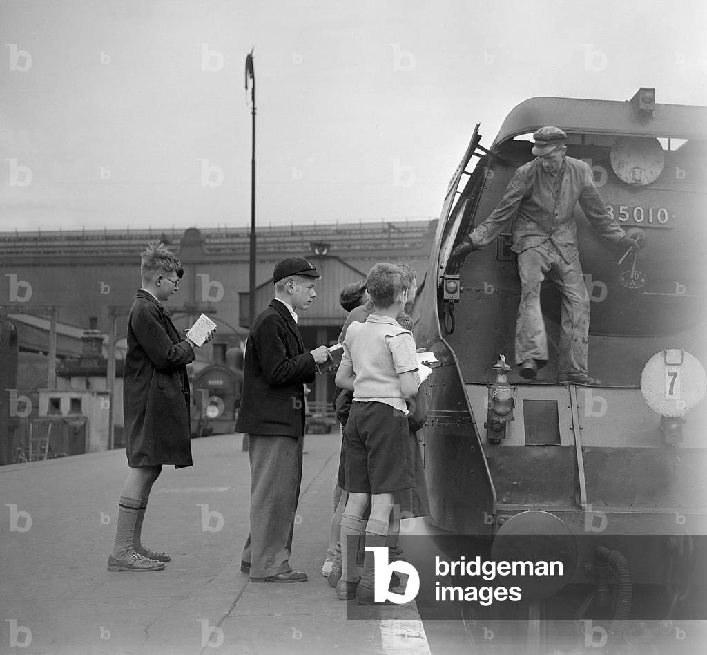 No, you can't see the number! the driver of Bulleid Merchant Navy No. 35010 Blue Star seems to be indicating to these politely determined youthful spotters with notebooks, 1952 (b/w photo)