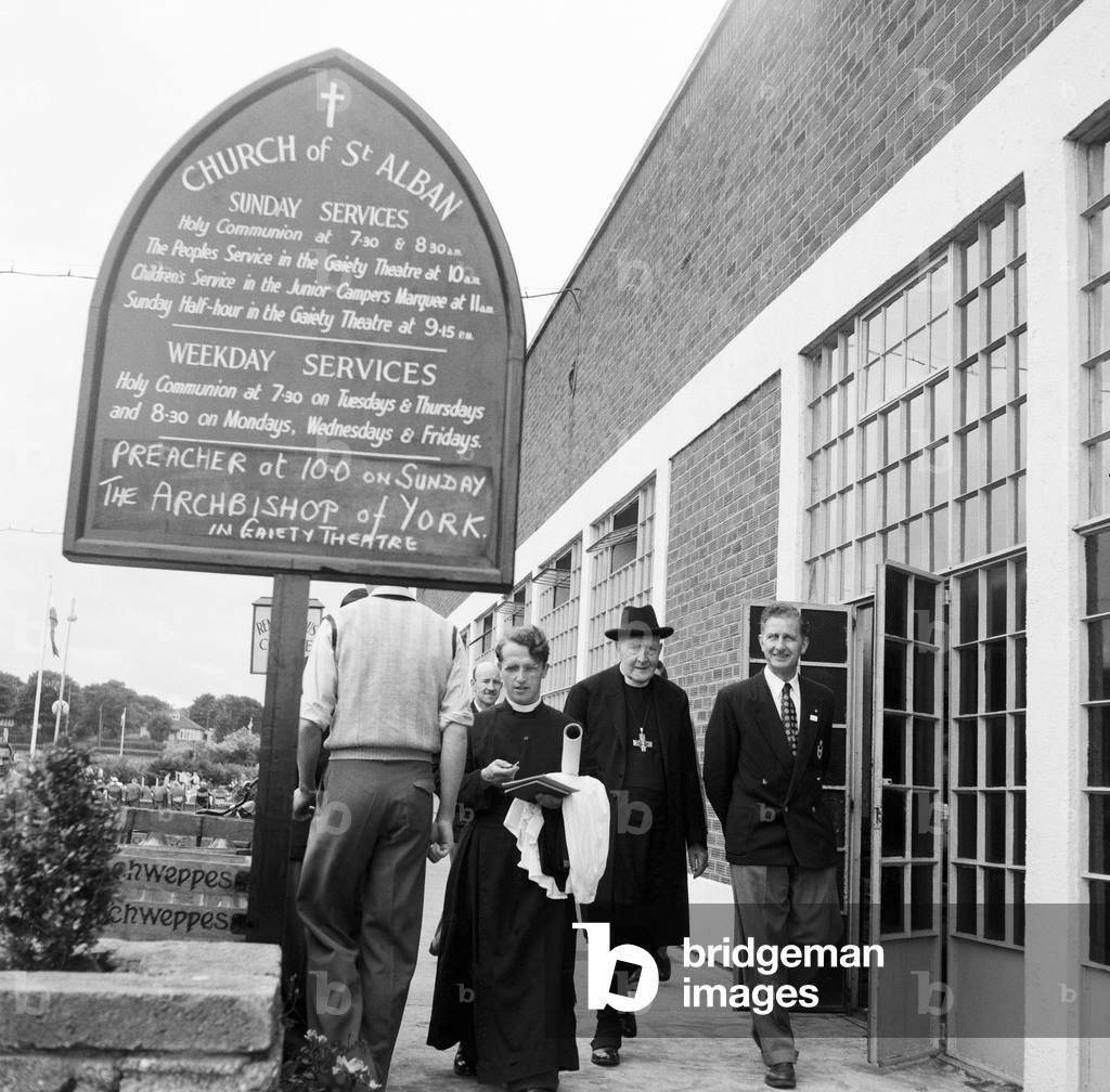 Dr. Cyril Garbett, the Archbishop of York visiting Butlins Holiday Camp, Filey, North Yorkshire. He visited Filey camp to conduct mass outdoor services once a year. 30th July 1954 (b/w photo)