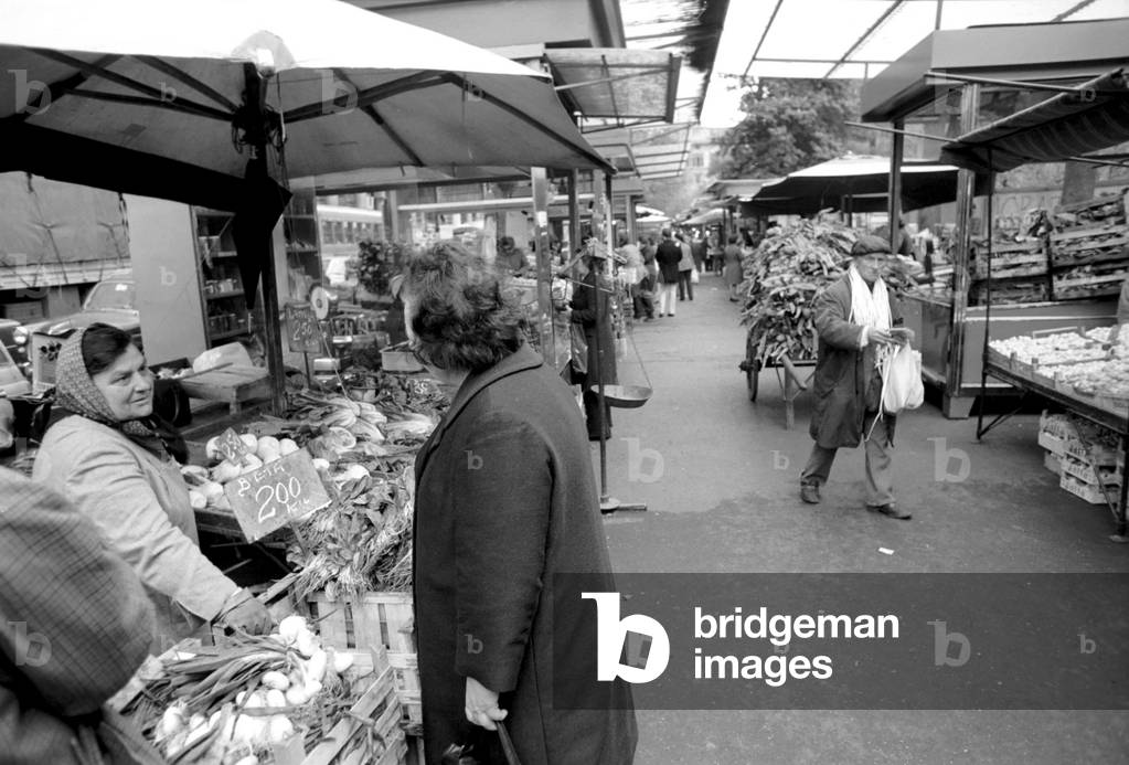 Woman buying fresh fruit and vegetables in a poor suburb on the outskirts of Rome, Italy, April 1975 (b/w photo)