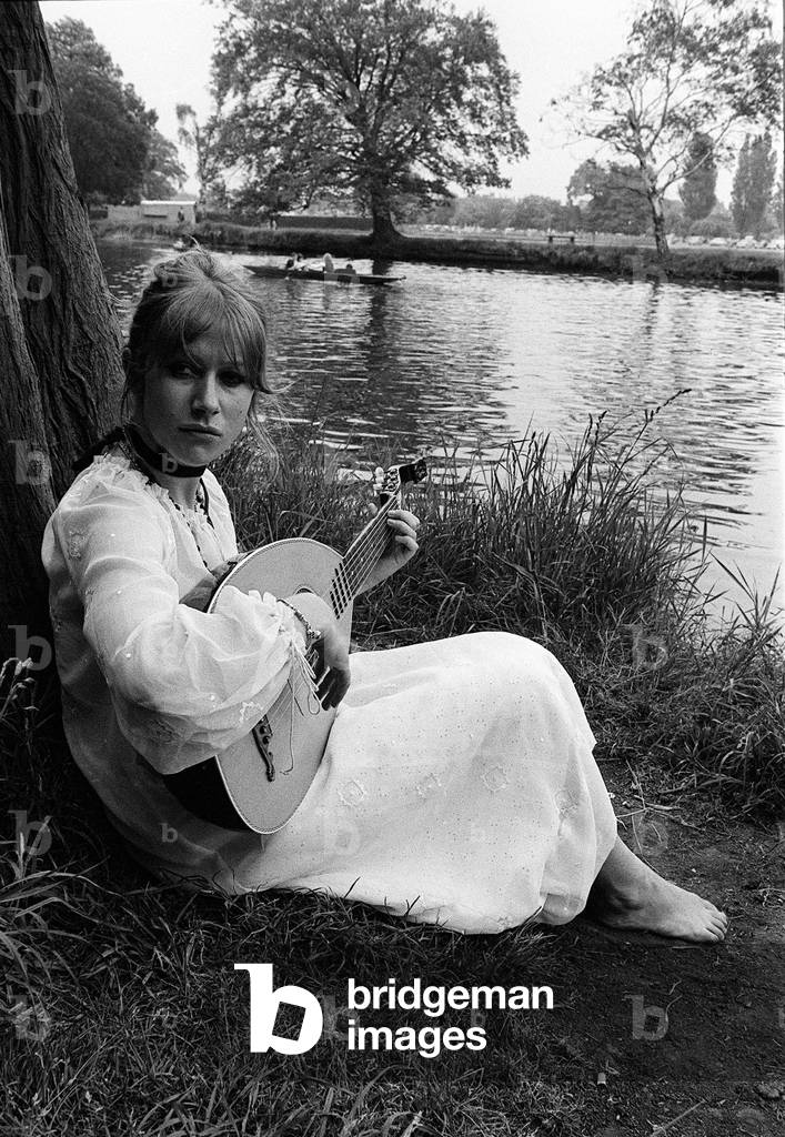 Actress Helen Mirren barefooted in her normal Maxi everyday dress practising icing on the bank of the Avon at Stratford Wark for her role at the Royal Shakespeare Theatre in Hamlet, where she is expected to sing and play the lute on stage, 28th, May 1970 (b/w photo)