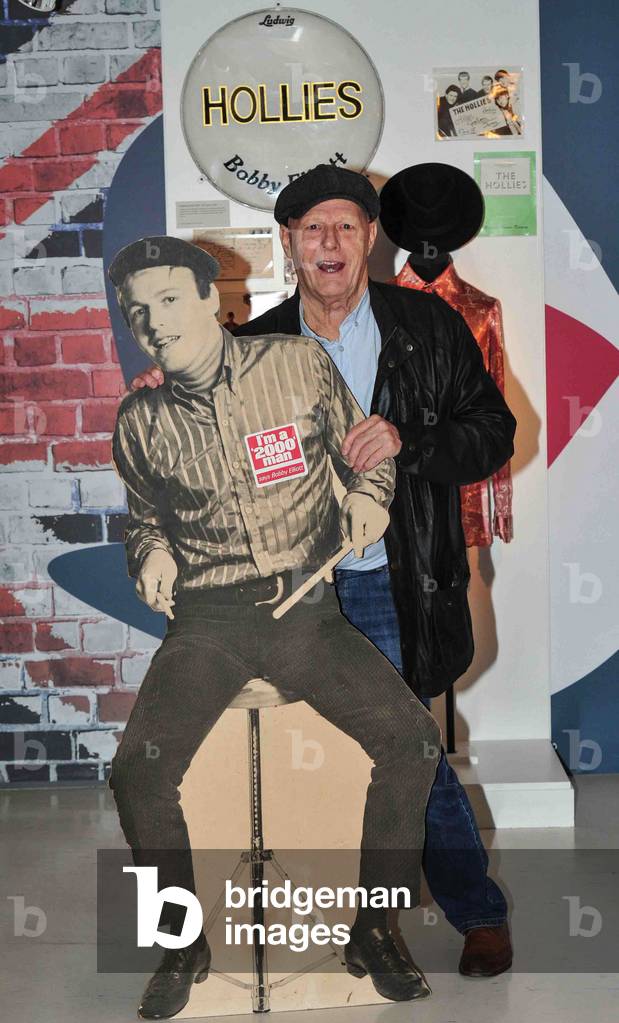 The Hollies drummer, Bobby Elliott, paid a visit to the new GRAMMY Museum exhibition in Liverpool. And the Sixties star reminisced about his part in the British Invasion of America in the early 1960s which was led by fellow bands like The Beatles, Kinks and Rolling Stones. The 72-year-old has loaned a number of items of The Hollies memorabilia to the show, including a Biba shirt from the 60s, album covers, promotional material, postcards and even a special Ludwig 400 snare drum which he played on most of the bands records during the decade. He said: Its a real joy. Ive got a barn full of this stuff at home so for someone to take it off my hands is great because it means we can spring clean! Hollies' drummer Bobby Elliot with some of the band's memorabilia, which is on display as part of the Grammy exhibition at The Beatles Story based at the Pier Head, Liverpool, 28/10/2014 (photo)