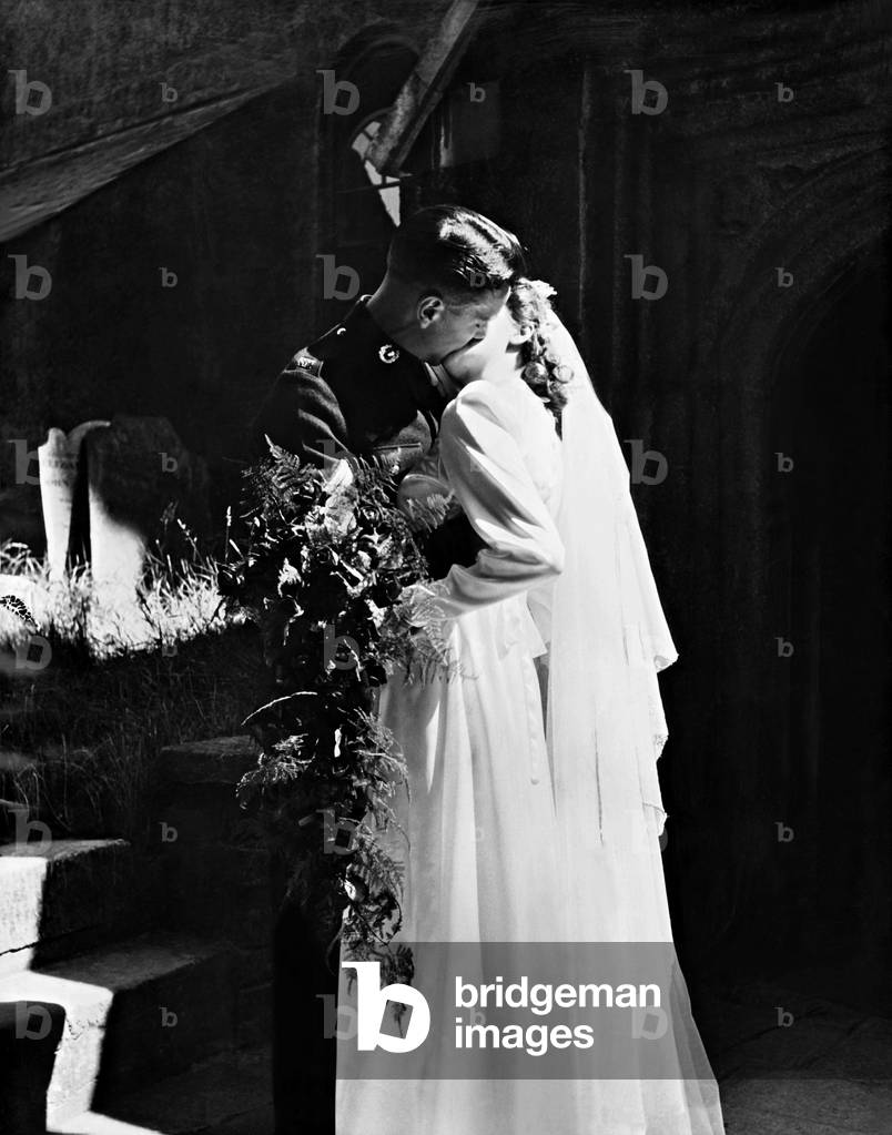 Bride and Groom snatch their first married kiss as they leave Stoke Damerel Church, Devonport. CPl. Kenneth Elwyn Davies, R.M., aged 21, of Treharris, S. Wales, and Miss Betty Margaret Harris, 19, of Milehouse, Plymouth, had just got married. 