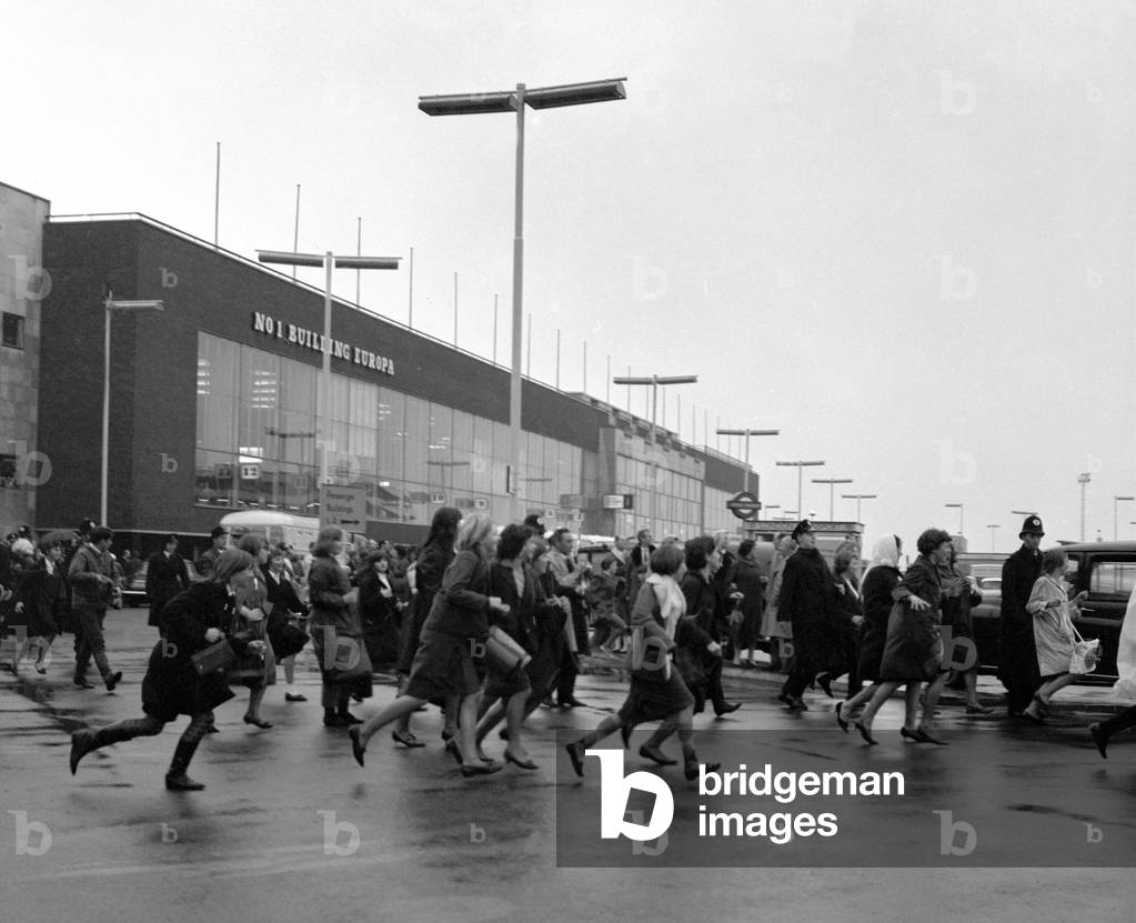 The Beatles arrive at London airport from Sweden. Fans running across the airport to greet them, 31st October 1963 (b/w photo)