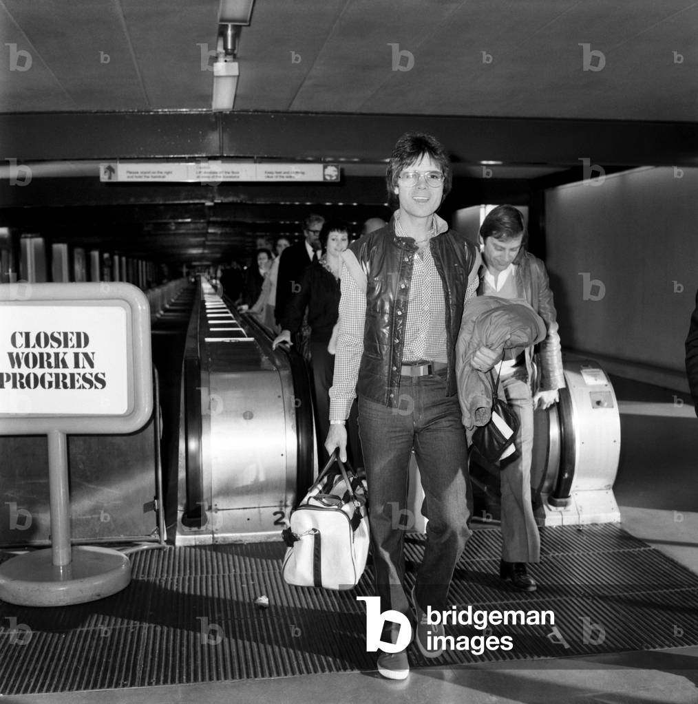 Departure of pop singer Cliff Richard flying to Los Angeles to make preparations for his next tour of U.S.A. his first tour in 17 years also to promote his latest record A Little in Love, January 1981 (b/w photo)