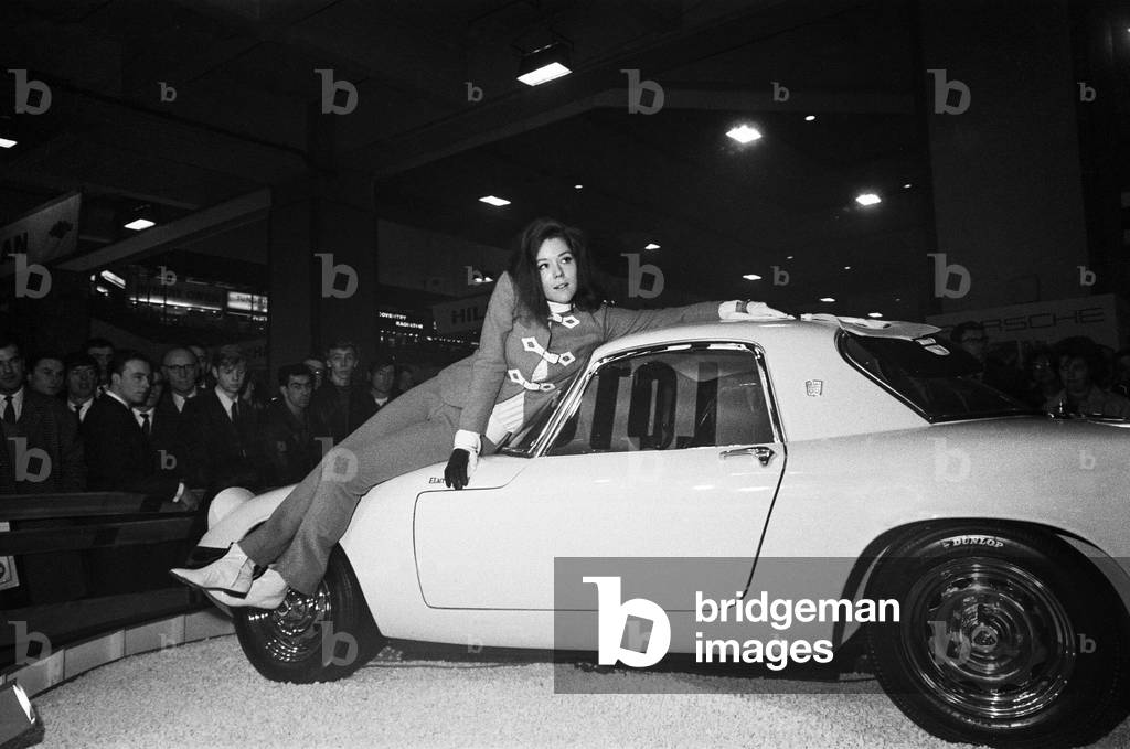 The British International Motor Show held at Earls Court, London from the 20th to the 30th October 1965. Actress Diana Rigg of the Avengers poses on a Lotus Elan at the show.