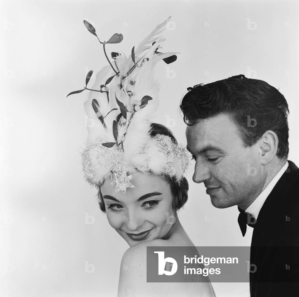 A model posing in the studio, wearing a Christmas bonnet designed by Madge Ehard.
22nd December 1957.